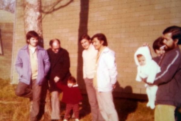 Armando Fuenzalida tenant sa petite fille par la main devant un bungalow au Château de Chamerolles- dec 1973