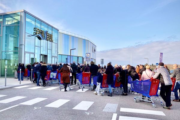 Dans le calme, une file d'attente de consommateurs avant midi devant un supermarché de Boisseuil