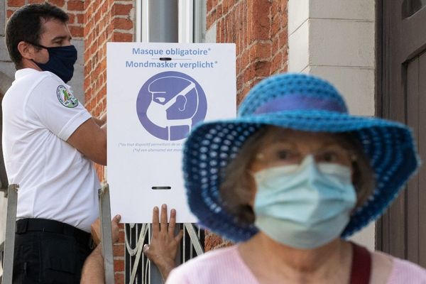 Masque et affiche de prévention dans la commune de Woluwe-Saint-Lambert, en région bruxelloise.