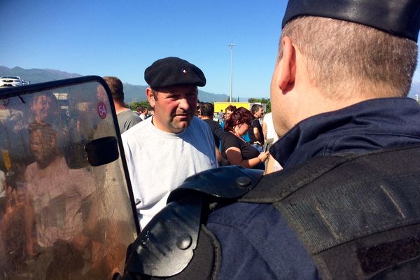 Rassemblés en groupe face à un cordon de CRS, les viticulteurs ont enflammé des pneus et installé quelques tables, alors que leur porte-parole échangeait avec le sous-préfet.