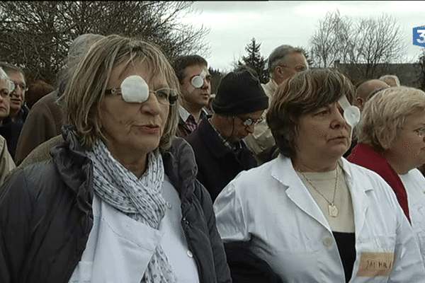 Personnels soignants et membres du comité de soutien de l'hôpital portent un pansement à l'oeil pour manifester leur opposition à la fermeture du service de chirurgie.