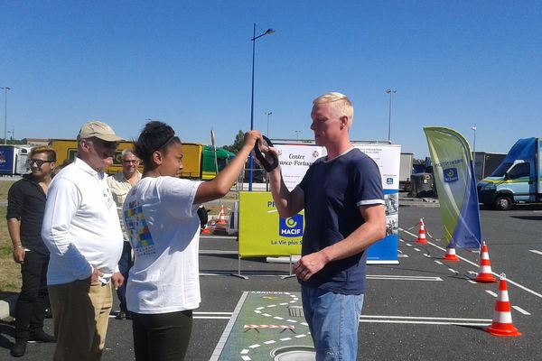 Un automobiliste est invité à tester des lunettes simulant les effets de l'alcoolémie au volant. 