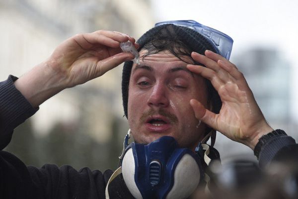 Un manifestant se lave les yeux avec une solution saline après les premiers gaz lacrymos