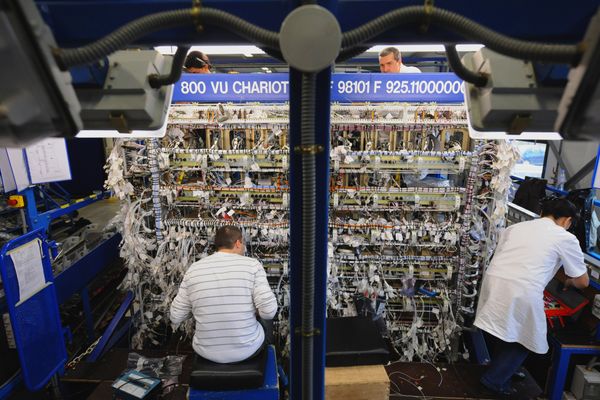 Deux techniciens travaillent sur une baie avionique chez Latelec (groupe Latécoère). 