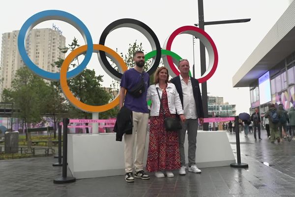 La famille du badiste Lucas Corvée pose devant les anneaux olympiques à Paris le  samedi 27 juillet 2024