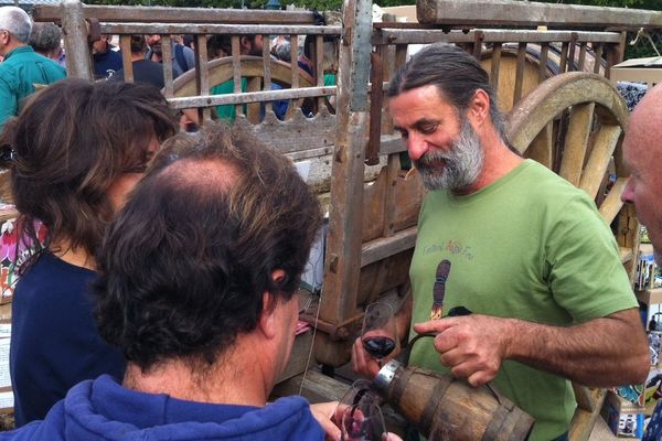 Olivier Cousin durant le pique nique urbain devant le tribunal d'Angers sert un verre de vin de sa production, le 2 octobre 2013