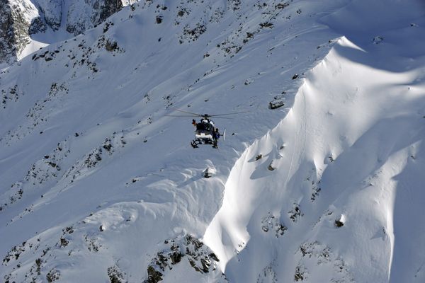 Un hélicoptère du Peloton de Gendarmerie de Haute Montagne (PGHM) survolant la Vallée blanche, dans le Massif du Mont Blanc. Image d'illustration. 