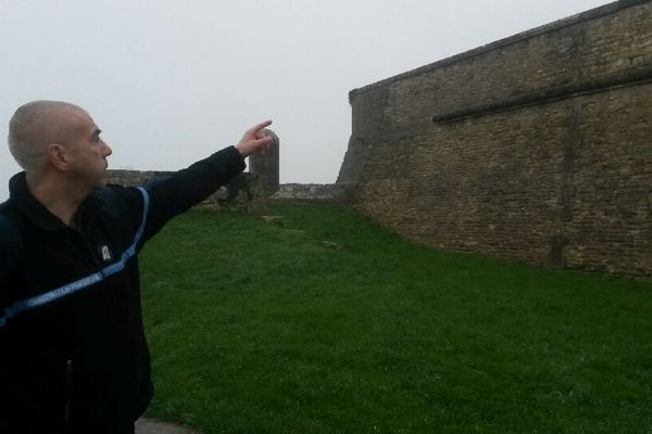 Un resposable syndical des gardiens de prison montre l'endroit par lequel se sont échappés les deux détenus en escaladant le mur de la citadelle.