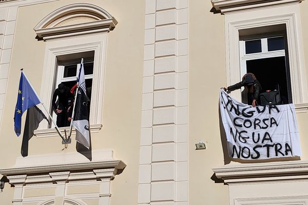 Les militants nationalistes accrochent les banderoles au fronton du tribunal.