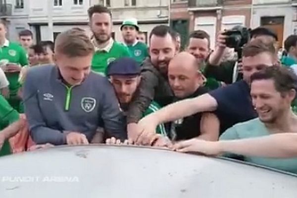 Les supporters tentent d'introduire des pièces ou des billets dans la voiture endommagée. 