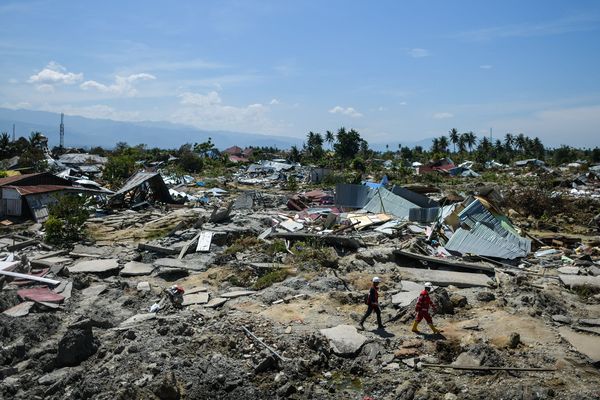 Des sauveteurs passent à travers les débris à Palu (Indonésie), le 5 octobre 2018.