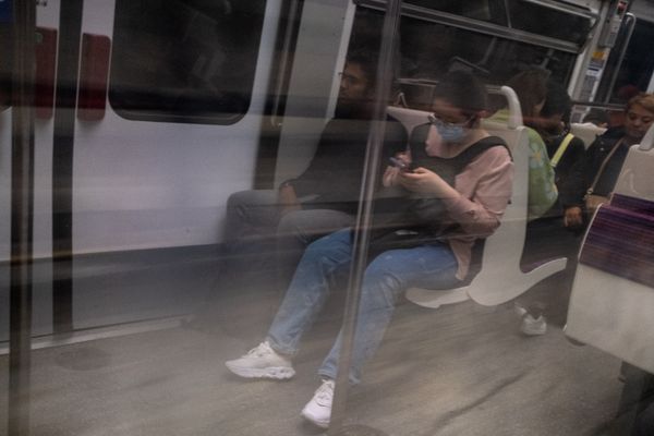 Une femme sur son portable dans le métro parisien