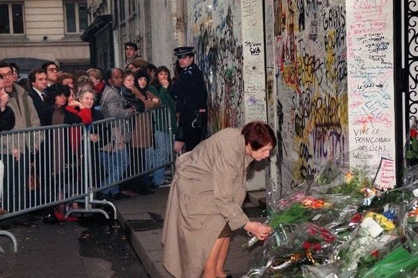 Une admiratrice dépose un bouquet de fleurs, le 04 mars 1991 rue de Verneuil à Paris, devant la façade de la résidence du chanteur et compositeur Serge Gainsbourg, deux jours après son décès.