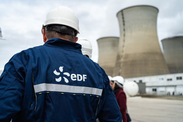 Un employé de l'entreprise EDF devant les tours de refroidissement du centre nucléaire du Bugey.