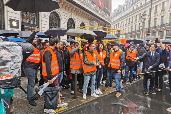 Dans leurs gilets oranges, les salariés tiennent le piquet de grève devant le magasin d'Opéra