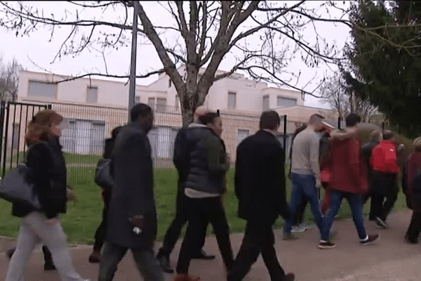 Des participants à la marche silencieuse, devant l'école du Mas de la Raz