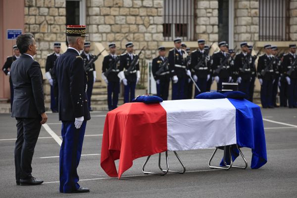 Nice (Alpes-Maritimes) le 2 septembre 2024 : le ministre de l'Intérieur sortant Gérald Darmanin (à gauche) se tient devant le cercueil après avoir remis la médaille de la Légion d'honneur à titre posthume au gendarme français Eric Comyn lors d'une cérémonie d'hommage.