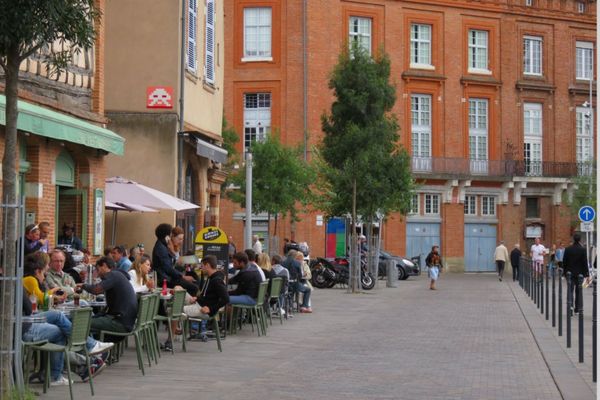 Au-dessus des terrasses de la place de la Daurade à Toulouse, le poulpe en céramique du street artiste Invader avant sa disparition durant l'été