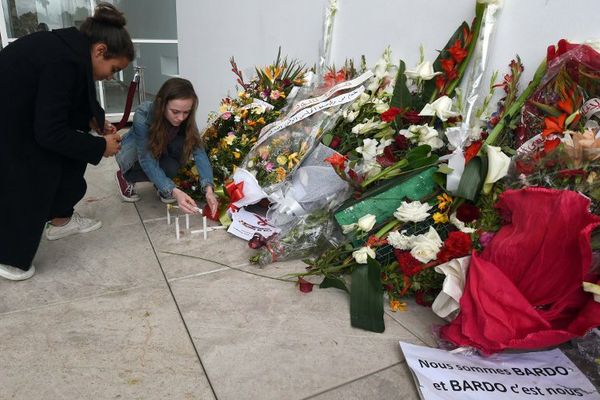 Des touristes rendent hommage aux victimes de l'attaque contre le musée du Bardo, à Tunis.