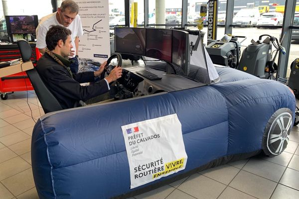 Un homme est au volant du simulateur de conduite déployé par la préfecture du Calvados, le 12 mars 2024, dans une entreprise de Mondeville.