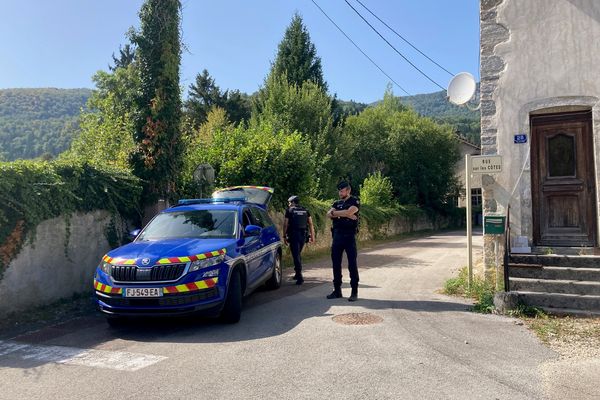 Un couple a trouvé la mort dans l'incendie de sa maison, le 23 août à Vaux-les-Saint-Claude dans le Jura. Les gendarmes sécurisent l'accès à la rue menant au sinistre.