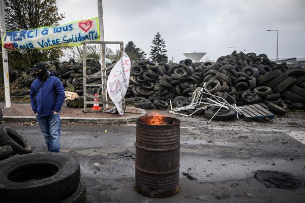 Un salarié de Michelin se tient devant le piquet de grève à l'entrée de l'usine de Cholet, en grève, le 21 novembre 2024.