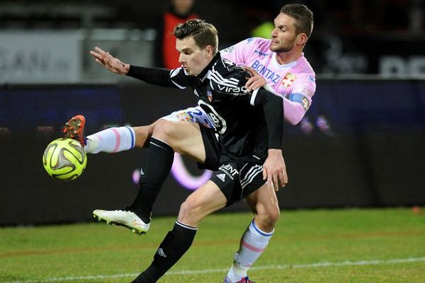 Le milieu de terrain d'Evian Cedric Cambon opposé au défenseur lorientais Benjamin Jeannot lors du match de Ligue 1 Evian TG - FC Lorient au Parc des Sports d'Annecy - 4/03/2015