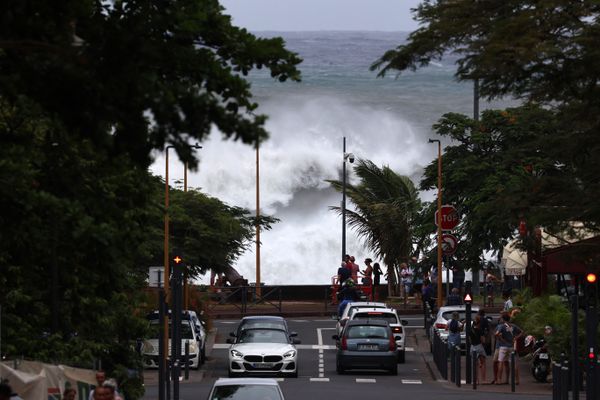 Des personnes regardent les vagues s'écraser à Saint-Denis de la Réunion le 14 janvier 2024