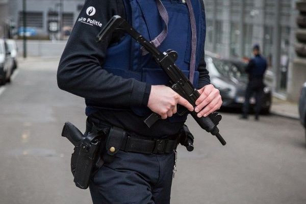 Un policier belge patrouille devant le siège de la police fédérale à Bruxelles, le 19 mars 2016, au lendemain de l'arrestation de Salah Abdelsam, suspect clé des attentats du 13 novembre 2015.