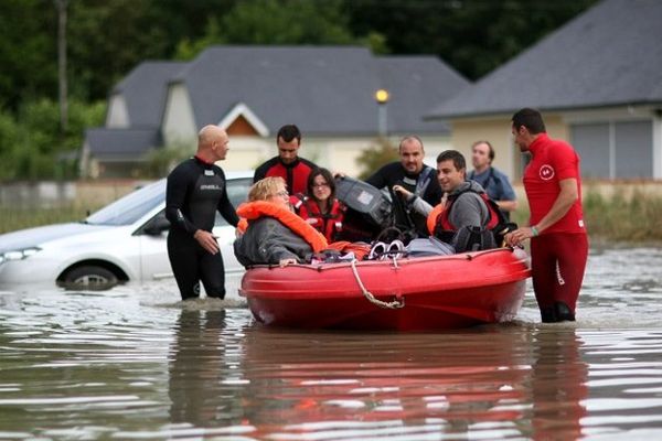 Les pompiers et les secouristes évacuent les habitants du village de Nay, complètement inondé, le 19 juin.