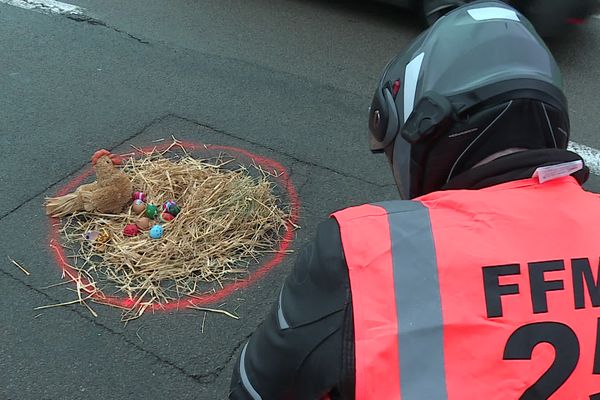 Marquage au sol, paille et œufs décorés aux couleurs de Pâques pour dénoncer l'état des infrastructures routières.