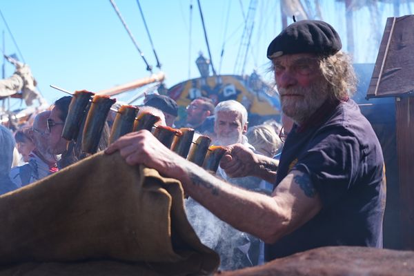 Devant un stand repérable à l'odeur et la fumée, René fume des harengs pour les visiteurs d'Escale à Sète 2024.