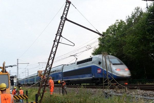 Des techniciens de la SNCF déplacent un pylône tombé sur les voies ferrées après un accident de voiture à Chalais près de Courlac dans le sud-ouest de la France, bloquant le trafic TGV le 17 juillet 2015.