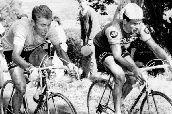 Le Français Jacques Anquetil (G), maillot jaune de leader, est au coude à coude avec son compatriote Raymond Poulidor dans l'ascension du Puy de Dôme, le 12 juillet 1964 lors de la 20ème étape du Tour de France, menant les coureurs de Brive à Clermont-Ferrand. A l'arrivée, Poulidor, 3ème, reprendra 42 secondes à Anquetil, insuffisant cependant pour empêcher le Normand de remporter à Paris son 5ème Tour de France.