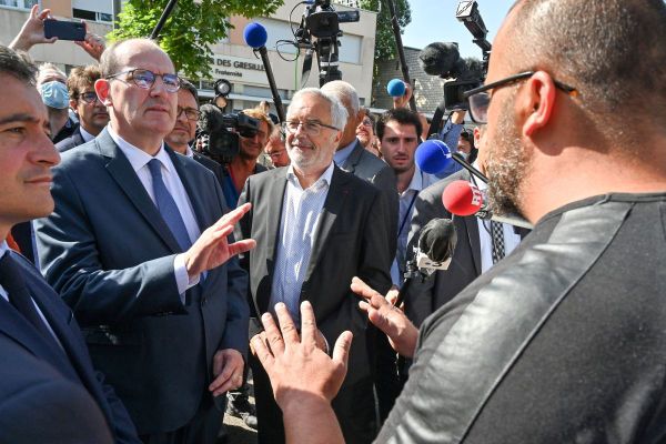 Le Premier ministre Jean Castex (au centre) discute avec un habitant du quartier des Grésilles, en compagnie du ministre de l'Intérieur Gérald Darmanin (gauche) et du maire PS de Dijon François Rebsamen (droite) le 10 juillet 2020.