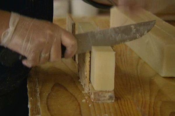 Le savon de fabrication artisanale est découpé à la main.