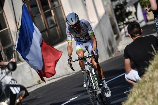 Un spectateur agite un drapeau français lors du passage du Tour de France entre Annecy et Le Grand-Bornand, dans les Alpes, le 17 juillet 2018. 
