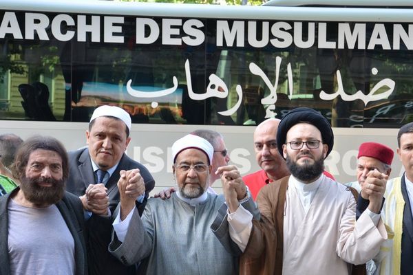 Les imams prient devant le bus avec lequel ils vont se rendre aux différents lieux touchés par le terrorisme. Champs-Elysées, le 8 juillet 2017.