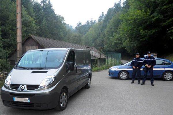 Deux gendarmes interdisent l'accès au parking forestier où ont été retrouvées les victimes de la tuerie.   