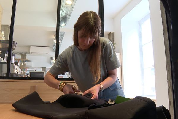 Solène Féron répare les combinaisons de surf dans son petit atelier à Biarritz.